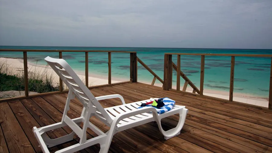 Lounger and snorkel gear on the beach deck above the sand